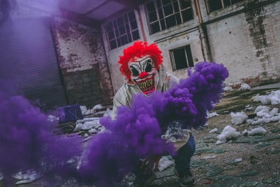 小丑拿着紫色的烟雾弹在了大楼
